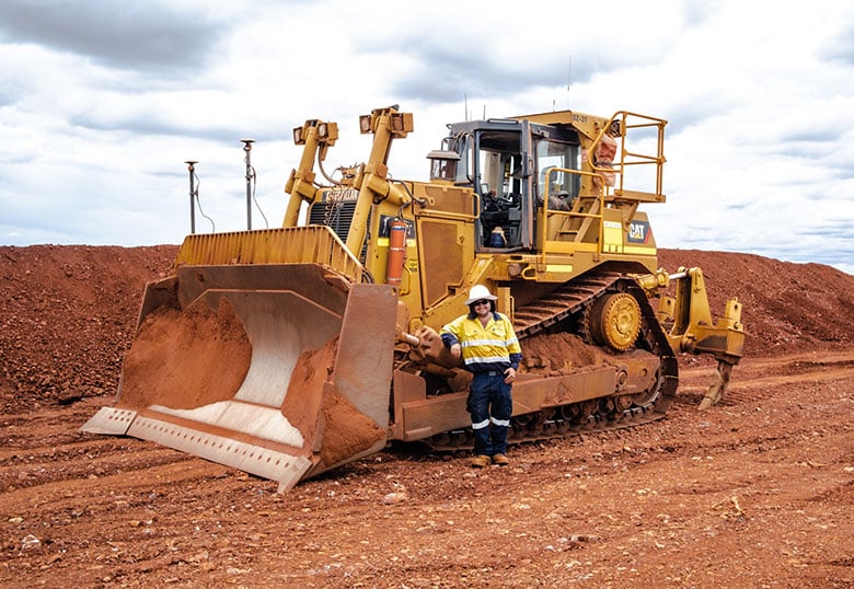 About RE:GROUP, RE:GROUP Employee stands in front of hire equipment in the pilbara